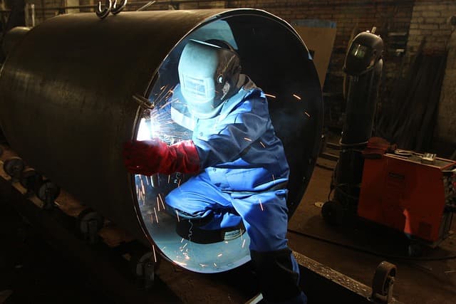 Soldador profesional trabajando en taller industrial